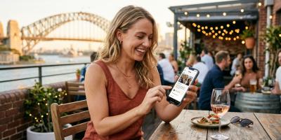 Woman browsing casual dating sites on phone at Sydney rooftop bar